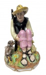 SUREDA, Espanha. Antiga e imponente escultura em porcelana esmaltada e policromada, representando figura masculina com ovelha. Manufatura na base. Medidas: 25 x 17,5 cm.