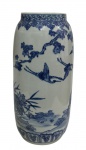 Antigo e imponente vaso em porcelana, de formato cilíndrico, esmaltado e decorado em azul sobre fundo branco, representando paisagem oriental com garças em voo, vegetação e elementos naturais. Borda ornamentada por frisos de inspiração oriental. Medidas: 41,5 x 19 cm.