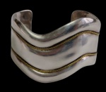 México - Antigo bracelete em prata teor 925, de formato rígido e aberto, com corpo ondulado ornamentado por frisos torcido dourado, contrastado na parte interna. Peso: 72,0 gramas. Medidas: 6,5 cm de diâmetro.