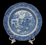 Antigo prato decorativo em porcelana, com decoração em azul sob esmalte representando paisagem oriental com pagodes, embarcação, árvores e aves, em composição inspirada no padrão Willow. Borda ricamente ornamentada com motivos geométricos e florais. Medidas: 25 cm de diâmetro.