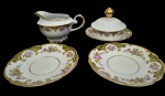 REAL. Conjunto em porcelana esmaltada e policromada, com decoração floral e frisos dourados, composto por 2 pires, 1 manteigueira com tampa e 1 leiteira. Manufatura no verso. Medidas: manteigueira 10 x 16 cm; pires 2 x 14,5 cm; leiteira 8 x 16 x 12 cm