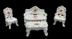 Vieira de Castro. Conjunto com 4 miniaturas em porcelana policromada e esmaltada, composto por sofá, mesa de centro, cadeira e poltrona, ricamente ornamentados em relevo com flores aplicadas e detalhes em ouro. Manufatura na base. Medidas: sofá 7 x 8 x 4 cm; cadeira 7 x 4 x 4 cm; cadeira de braços 7 x 4 x 4 cm; mesa de centro 4 x 7 x 4 cm.