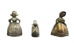 Lote contendo 3 sinetas de mesa em metal, 2 em formato de figuras femininas com trajes típicos e uma no feitio de cisne. Medidas: 8 x 5 cm, 8 x 5 cm e 5 x 6 x 3 cm.