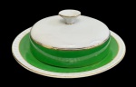 Brennand Recife, Brasil - Manteigueira em porcelana esmaltada, composta por base e tampa, com decoração em faixa verde e frisos dourados. Manufatura marcada na base. Medidas: 7 x 19 cm.