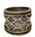 Imponente anel em prata, com aplicações em ouro e decoração em relevo geométrico ornamentada por pequenas pedras incolores. Aro 20. Peso: 17,2 gramas.