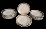 Steatita. Conjunto de 24 pratos fundos em porcelana esmaltada na cor branca, decorado com listra prata ornamentada. Medindo: 3 x 21 cm.
