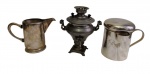 Lote com três peças em metal espessurado a prata, composto por samovar, leiteira e caneca com tampa, com alças laterais e detalhes torneados. Medidas: 13 x 11 x 8 cm (samovar), 13 x 9 x 5,7 cm (leiteira) e 11 x 10 x 8,7 cm (caneca).