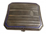 Antiga cigarreira em metal espessurado a prata, de formato retangular com cantos chanfrados, ricamente gravada com frisos geométricos, reserva lisa para monograma e filete em esmalte azul, apresentando bordas ornamentadas em relevo vegetal. Medidas: 8,7 x 7,5 cm.