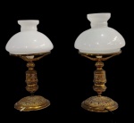Par de antigos abajures, com bases em metal dourado ricamente cinzelado em relevo  e cúpulas em vidro leitoso branco. Medidas (cada): 36 x 15 cm.
