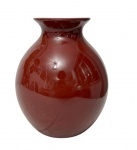 Polovi. Antigo vaso em porcelana esmaltada, de formato bojudo com colo estreito e borda levemente expandida, na cor vinho (bordô) de acabamento brilhante. Apresenta pequeno fio de cabelo na borda. Medidas: 17 x 14,5 cm.
