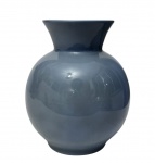 Polovi Germer - Antigo vaso em porcelana esmaltada na tonalidade azul, de corpo bojudo e boca alargada. Marca da manufatura na base. Apresenta pequeno fio de cabelo na borda. Medidas: 17 x 14,5 cm.