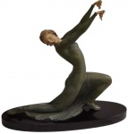 Escultura Art Déco em petit bronze, representando figura feminina em elegante composição de movimento, com rosto e mãos em baquelite, sobre base oval em madeira ebonizada. Medidas: 42 x 45 x 15 cm.