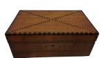 Antiga caixa em madeira marchetada, com decoração geométrica em marchetaria contrastante na tampa e nas laterais, tampa articulada e fechadura frontal. Apresentando desgastes e necessitando de restauração. Medidas: 17 x 40 x 24 cm.