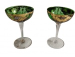 Antigo par de imponentes taças em cristal veneziano, na cor verde translúcido, com hastes torcidas e bojo ricamente ornamentado com reservas douradas, arabescos e delicada decoração floral policromada, executada à mão. Medidas: 17,5 x 11,2 cm. Apresenta desgastes.