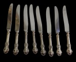 Conjunto com 8 facas de mesa em prata de lei, com cabos em prata Sterling ricamente cinzeladas em relevo, de inspiração Rococó, e lâminas em aço inox. Medidas aproximadas: 24 cm de comprimento cada.