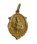 Pingente religioso em ouro, com representação de santo em relevo em ambas as faces, emoldurado por contorno recortado de inspiração barroca. Peso: 1,09 gramas.