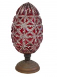 Antiga pinha decorativa em cristal, lapidada em alto-relevo com motivos geométricos, na tonalidade rubi, sobre base em metal dourado. Medidas: 15 cm de altura.