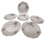 C.T. Poland - Oito pratos rasos em porcelana polonesa esmaltada, com decoração floral policromada, bordas recortadas e filetadas a ouro. Marcadas na base. Medidas: 25 cm.
