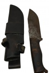 Cutelaria. Antiga faca de caça, com lâmina em carbono e cabo anatômico em madeira. Acompanha bainha em couro com passador para cinto. Apresenta marcas de oxidação na lâmina compatíveis com o tempo de uso. Medidas: com bainha 8 x 30 cm; sem bainha 4 x 28 cm.