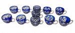 Conjunto com 11 canecas em cristal azul cobalto, ricamente lapidadas, apresentando três padrões decorativos distintos, todos com motivos geométricos e florais, alças translúcidas e bases facetadas. Medidas: 12,5 x 9 x 7 cm.