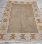 Tapete Kilim Maghrebi, confeccionado em lã, de tecelagem plana (flat weave), apresentando campo central em tonalidade bege, emoldurado por ampla cercadura decorada com motivos geométrico. Medidas: 200 x 130 cm.