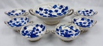 WEISS. Antigo conjunto de sobremesa em faiança branca manufatura Weiss com belo padrão floral  em azul pintados à mão tendo folhagem e sutis detalhes  em dourado e bordas com flietação em ouro e alças com detalhes geométricos em dourado. Marcado na base com numeração composto de seis tigelas menores e uma maior com duas alças em cada peça.  Medindo: 10 x 30 x 24 cm e 6 x 13 x 18 cm. Um consume com bicado.