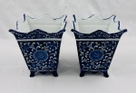 Par de vasos cachepot em porcelana azul cobalto com belo trabalho floral nas cores branca, amarela e azul claro ao gosto português com bordas onduladas pontiagudas sobre 4 pés e entremeio com detalhe decorativo. Medindo: 19 x 15 x 16 cm.