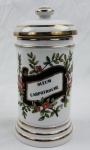 Teixeira, antigo pote de farmacia / botica em porcelana esmaltada, com tampa, decoração policromada representando ramos floridos, inscrição "Oleum Carpotroche", com detalhes em ouro. Manufatura ao fundo. Medidas: 21 x 11 cm.