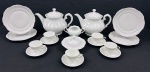Conjunto para café em porcelana branca esmaltada e vitrificada, com decoração em relevo formando padrão losangular e bordas em relevo. Composto por 2 bules, 5 xícaras para café com seus respectivos pires, 1 açucareiro (sem tampa), 1 manteigueira com tampa adaptada e 4 pratos de sobremesa. Medidas: bules 20 x 25 x 17 cm; pratos de sobremesa 19 cm de diâmetro.