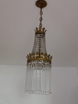 Antigo lustre de teto em metal dourado, ornamentado com pingentes facetados e canutilhos de vidro, de formato cônico. Peça desmontada, necessitando montagem. Medida: 76 cm de altura total.