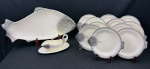 Conjunto para peixe em faiança esmaltada e policromada, composto por 1 travessa em formato de peixe, 1 molheira sobre presentoir e 11 pratos, em formato de peixe, com decoração em relevo e pintura naturalista. Medidas: molheira 12 x 27 x 15 cm; pratos 27 x 24 cm; travessa 60 x 30 cm. Travessa com quebra na cauda, a molheira com discreto bicado e 2 pratos com bicados.