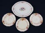 J. & G. Meakin England - Sunshine "Woodside". Conjunto em faiança inglesa esmaltada, composto por 1 travessa oval e 3 pratos de sobremesa, decorados com guirlandas de frutas e flores policromadas, bordas recortadas e delicado filete dourado. Apresentam craquelê. Medidas: travessa 29 x 23,5 cm; pratos 17,5 cm de diâmetro.