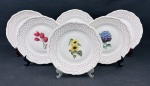 Wabrzych, Poland. Seis pratos rasos em porcelana esmaltada, com bordas em relevo, ornamentação em filetes dourados e delicado padrão estrelado em vermelho, decorados ao centro com diferentes motivos florais policromados. Apresenta 1 prato com 2 pequenos bicados no verso. Medidas: 23,5 cm de diâmetro.