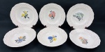 Wabrzych, Poland. Seis pratos fundos em porcelana esmaltada, com bordas em relevo, ornamentação em filetes dourados e delicado padrão estrelado em vermelho, decorados ao centro com diferentes motivos florais policromados. Apresenta 1 prato com 2 pequenos bicados no verso. Medidas: 4,5 x 23 cm de diâmetro.