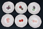Wabrzych, Poland. Seis pratos sobremesa em porcelana esmaltada, com bordas em relevo, ornamentação em filetes dourados e delicado padrão estrelado em vermelho, decorados ao centro com diferentes motivos florais policromados. Apresenta 1 prato com 2 pequenos bicados no verso. Medidas: 17,5 cm de diâmetro.