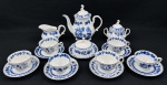 Steatita. Serviço para chá em porcelana esmaltada, decorado  no padrão "Cebolinha" em tons de azul, composto por 6 xícaras de chá com seus respectivos pires, 1 bule, 1 leiteira, 1 açucareiro e 1 manteigueira. Medidas: bule 22 x 22 cm; leiteira 10 x 14 cm; açucareiro 14 x 15 cm; manteigueira 10 x 15 cm. Observação: 2 xícaras com seus respectivos pires apresentam tonalidade de azul ligeiramente mais escura. O bule, a leiteira e o açucareiro apresentam bicados.