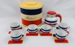 Conjunto com 14 peças da linha "Bistrot", composto por 6 xícaras em porcelana, 6 porta-xícaras / copos em acrílico, 1 bule em porcelana com tampa e alça em plástico rígido e 1 balde de gelo em plástico rígido, todos decorados com listras tricolores em azul, branco e vermelho. Medidas: balde 35 x 22 cm, porta-xícaras 10 x 10 cm e bule 14 x 14 cm.