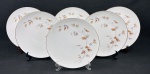 Noritake Japan. Seis pratos rasos em porcelana japonesa esmaltada, delicada decoração de folhagens e frutos em policromia, bordas filetadas a ouro. Manufatura no verso. Medidas: 27 cm.