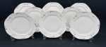 Czechoslovakia. Oito pratos rasos em porcelana esmaltada, de formato oitavado, decorados com delicados ramos florais em grisaille e filetes em prata. Manufatura no verso. Medidas: 24 cm. Um com restauro