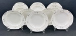 Czechoslovakia. Onze pratos fundos em porcelana esmaltada, de formato oitavado, decorados com delicados ramos florais em grisaille e filetes em prata. Manufatura no verso. Medidas: 4,5 x 24 cm.