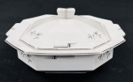 Czechoslovakia. Terrina em porcelana esmaltada, de formato oitavado, decorados com delicados ramos florais em grisaille e filetes em prata. Manufatura no verso. Medidas: 13 x 25 x 23 cm.