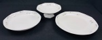 Czechoslovakia. Fruteira e 2 travessas redondas em porcelana esmaltada, de formato oitavado, decorados com delicados ramos florais em grisaille e filetes em prata. Manufatura no verso. Medidas: 9 x 23 cm, 30 cm e 34 cm.