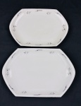 Czechoslovakia. Duas travessas em porcelana esmaltada, de formato oitavado, decorados com delicados ramos florais em grisaille e filetes em prata. Manufatura no verso. Medidas: 28 x 19 cm e 33 x 25 cm.