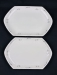 Czechoslovakia. Duas travessas em porcelana esmaltada, de formato oitavado, decorados com delicados ramos florais em grisaille e filetes em prata. Manufatura no verso. Medidas: 38 x 24,5 cm e 43 x 28 cm.