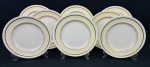 Johnson Bros.,England. Oito pratos rasos em faiança inglesa, padrão Old English, com borda serrilhada, ornamentada em relevo, aba em tom creme sobre fundo marfim e detalhes e filetes em ouro de motivos florais. Manufatura no verso. Medidas: 25 cm de diâmetro. Craquelê.