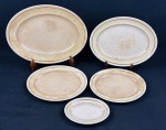 Johnson Bros.,England. Cinco travessas em faiança inglesa, padrão Old English, com borda serrilhada, ornamentada em relevo, aba em tom creme sobre fundo marfim e detalhes e filetes em ouro de motivos florais.  Manufatura no verso. Medidas:  14 x 20 cm à 34 x 42 cm. Craquelê. Apresentam manchas, peças vendidas no estado que se encontam.