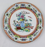 Prato decorativo em porcelana chinesa, com decoração oriental pintada à mão em esmaltação policromada, representando composição floral com pássaros e elementos fitomorfos, emoldurada por rica cercadura ornamentada com reservas florais, arabescos e delicado filete dourado na borda. Medida: 25 cm de diâmetro.