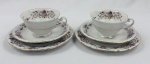 TK Thun Czechoslovakia - Par de trios para chá em fina porcelana, decoradas com delicados motivos florais policromados, arabescos em douração e bordas filetadas a ouro. Composto de 2 xícaras, 2 pires e 2 pratos para sobremesa.  Manufatura marcada na base. Total de 6 peças. Medidas: 17 cm (prato)