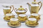 Mauá. Elegante conjunto para café em fina porcelana, ricamente decorado em tonalidade amarela com arabescos em relevo e acabamento filetado a ouro. Composto por bule, leiteira, açucareiro com tampa e 5 xícaras com respectivos pires.