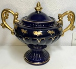 Magnífica e grande ânfora em porcelana na cor azul com tampa e alças douradas. Mede: 33 x 39 cm. (com alças coladas).